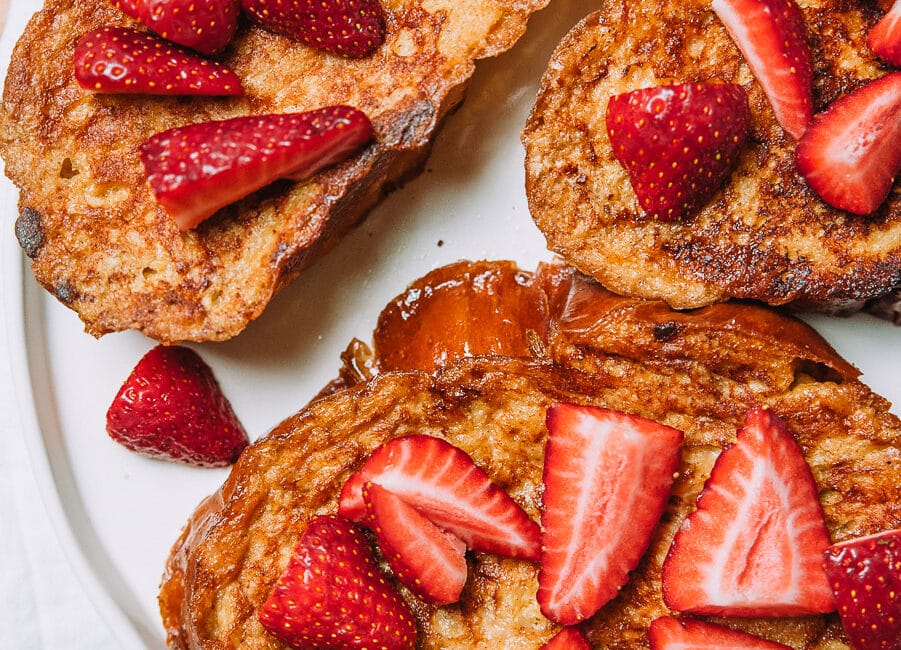 French toast topped with strawberries on a white plate
