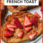 Thick slices of french toast with strawberries on a white plate.