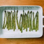 Roasted asparagus in a white baking dish